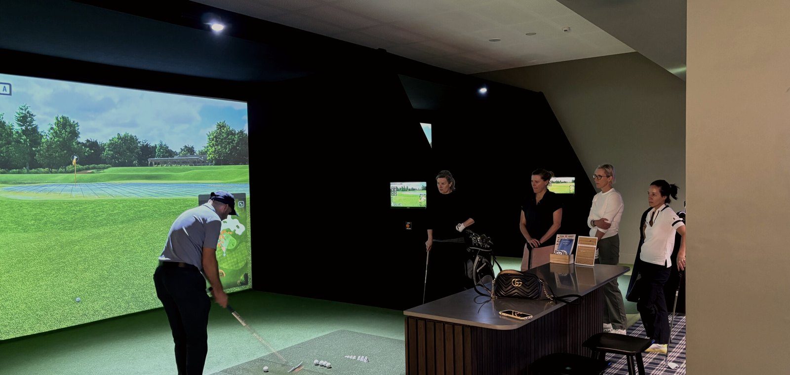 A player teeing off on a TrackMan simulator bay at Howe2Golf